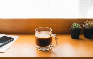 Coffee Morning,Coffee in a mug on a wooden table with a notebook photo