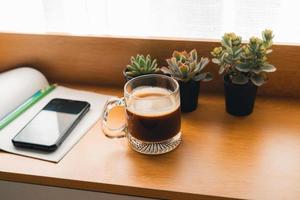 Coffee Morning,Coffee in a mug on a wooden table with a notebook photo