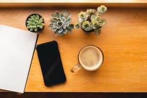 café por la mañana, café en una taza sobre una mesa de madera con un cuaderno foto