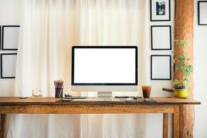 computadora en un escritorio en casa con cortinas blancas foto