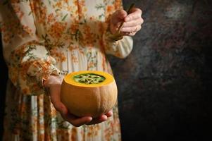 Woman holding Healthy Pumpkin Cream Soup photo