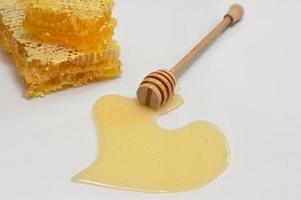 Honeycomb, honey dipper and heart shape of honey photo