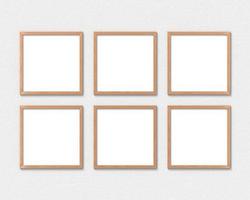 conjunto de 6 maquetas de marcos de madera cuadrados colgados en la pared. base vacía para imagen o texto. representación 3d foto