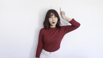 Shock Asian beautiful girl point above with red shirt in white background photo