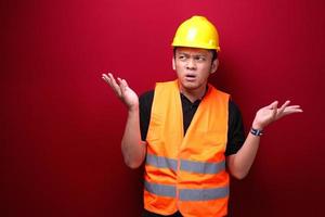 Thinking Young asian man worker is seriously think gesture on red background photo