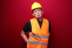 Sad and upset young asian man worker with serious pain in back man photo