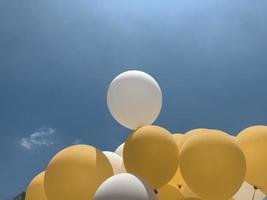 Yellow and white balloon with blue background photo