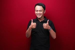 Happy Young Asian man with smiling face and thumbs up or ok sign photo