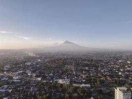 vista aérea del monte merapi al atardecer y la ciudad de yogyakarta, indonesia. ciudad con vistas al fondo de la montaña. foto