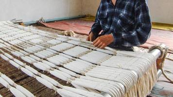 weaving and manufacturing of handmade carpets. man's hands behind a loom photo