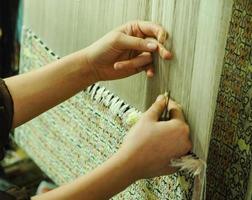 weaving and manufacturing of handmade carpets closeup photo