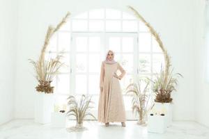 Retrato de cuerpo entero de dama con vestido de novia, maquillaje de boda en hijab. vestido de novia malayo o indonesia, concepto de belleza o eidul fitri. Hermosa mujer musulmana del sudeste asiático posando en traje de islam foto