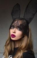 portrait of disproportionate, modern, stylish, fashionable sad woman after plastic surgery or after filters in photo edit application in bunny lace ears