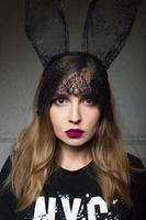 portrait of beautiful stylish fashionable sad woman in bunny lace ears photo