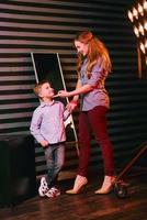 portrait of stylish cute little boy with beautiful mom in photo studio