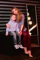 portrait of stylish cute little boy with beautiful mom in photo studio