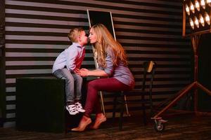 portrait of stylish cute little boy with beautiful mom in photo studio