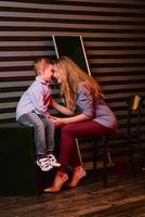 portrait of stylish cute little boy with beautiful mom in photo studio