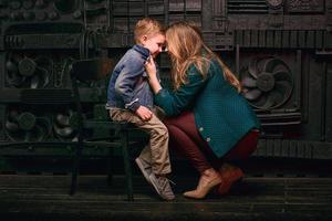 retrato de un niño lindo y elegante con una hermosa mamá en un estudio fotográfico foto