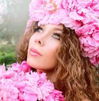 caucasian beautiful woman with a wreath of pink peonies on her head. Spring, blossom, fairy concept photo