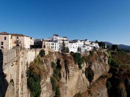 Amazing village of Ronda. White villages in the province of Malaga, Andalusia, Spain. Beautiful village on the cliff of the mountain. Touristic destination. Holidays and enjoy the sun. photo