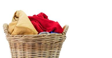 Clothes in a laundry wicker basket isolated on white background. photo