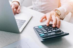 los empresarios asiáticos usan una calculadora para calcular impuestos e ingresos