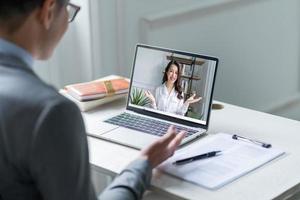 gerente masculino asiático entrevistando a candidatos de forma remota a través de videollamadas foto