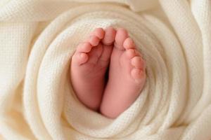 Small beautiful legs of a newborn baby in the first days of life photo