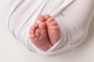 Small beautiful legs of a newborn baby in the first days of life photo