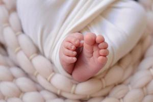 Small beautiful legs of a newborn baby in the first days of life photo