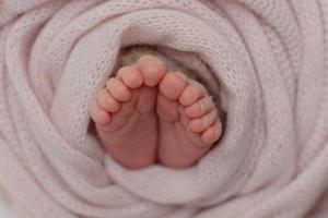 Small beautiful legs of a newborn baby in the first days of life photo