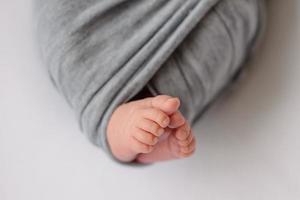 Small beautiful legs of a newborn baby in the first days of life photo
