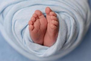 Small beautiful legs of a newborn baby in the first days of life photo