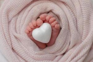 Small beautiful legs of a newborn baby in the first days of life photo