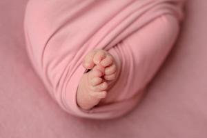 Small beautiful legs of a newborn baby in the first days of life photo