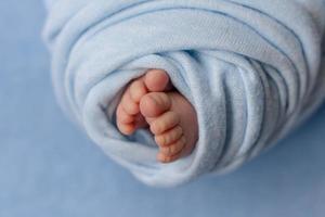 Small beautiful legs of a newborn baby in the first days of life photo