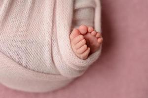 Small beautiful legs of a newborn baby in the first days of life photo