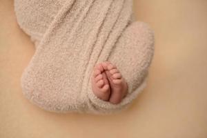 Small beautiful legs of a newborn baby in the first days of life photo