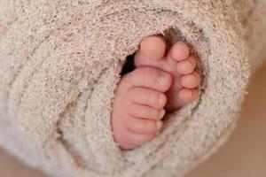 Small beautiful legs of a newborn baby in the first days of life photo