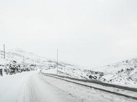 Driving through snowy road and landscape in Norway. photo