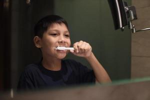 Asian boy brushing teeth in the bathroom photo