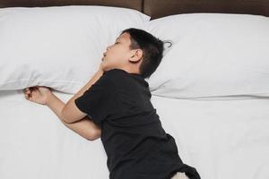 Asian boy sleeping on the bed photo