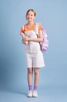 Young Asian student posing on blue background photo