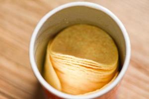 Potato hips on cans paper, Stacked potato chips is snack in package ready to eat and fat food or junk food photo