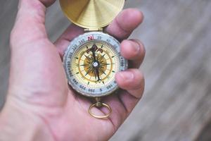 Navigational compass travel and tourist concept - Man explorer searching direction with compass for map photo