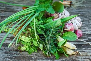 Hierbas frescas naturales y especias sobre fondo de madera rústica en la cocina para el ingrediente alimentario - concepto de jardín de hierbas de cocina foto
