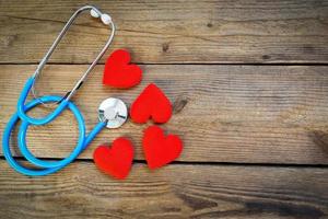 Heart health and red heart with stethoscope on wooden background - world heart day world health day or world hypertension day and health insurance concept photo