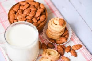 almond milk glass and cookie for breakfast health food - almonds nuts on wooden bowl background photo