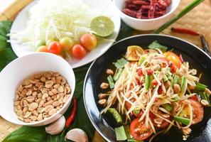 Thai food top view - papaya salad spicy with yardlong bean herbs and spices ingredients chilli tomato peanut garlic served on table